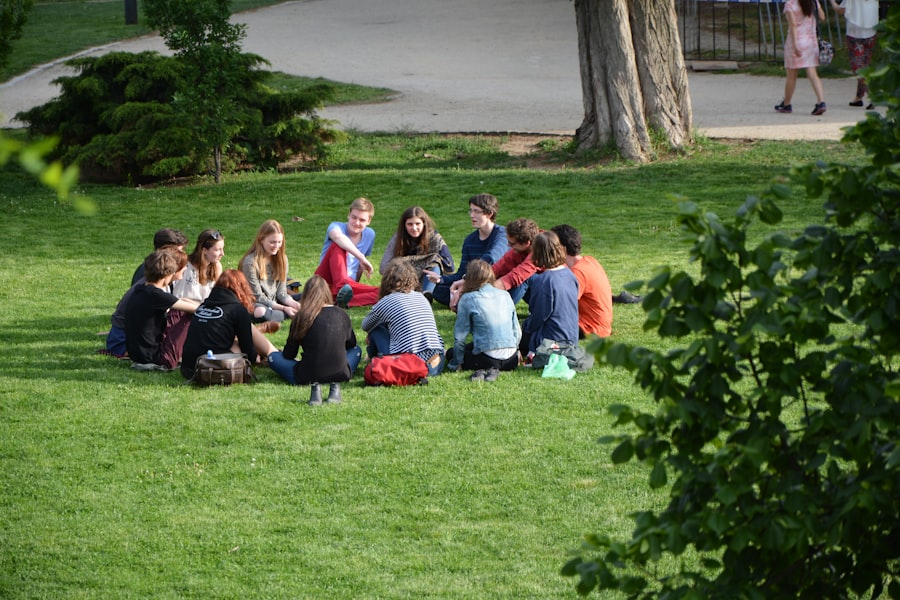 A circle of members sitting together on the park lawn