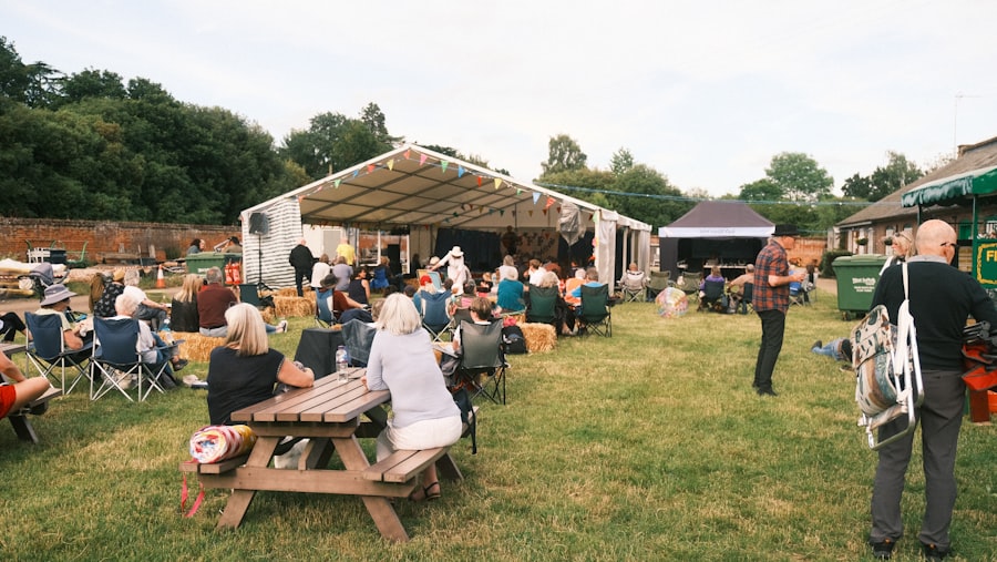 A community summer fete with tents and picnic tables on the green